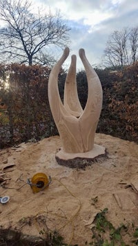 a wooden sculpture is being made in a wooded area