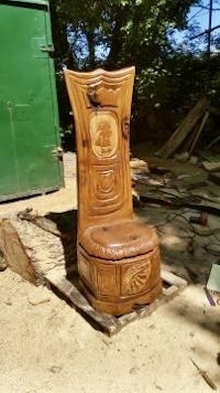 a wooden chair sitting on top of a pile of dirt