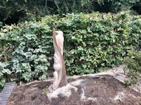 a sculpture made from a tree stump in a garden