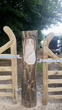 a wooden gate with an owl carving on it