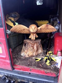 a wooden owl sitting in the back of a van