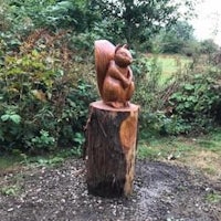 a sculpture of a squirrel on a tree stump