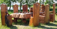 a wooden table and chairs in a grassy area