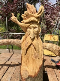 a wood carving of a man with a beard and hat