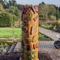 a wooden tree stump in a garden