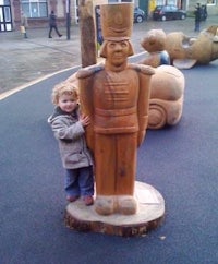 a child standing next to a wooden statue of a nutcracker